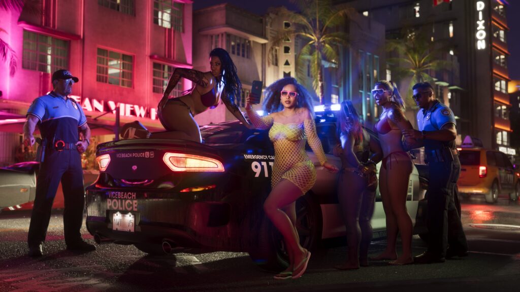 Police officers and a group of people beside a patrol car at night in Vice City