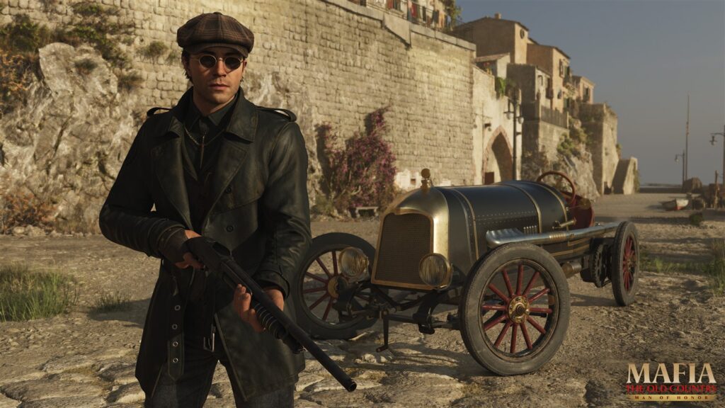 A man with a gun beside an early century racing car
