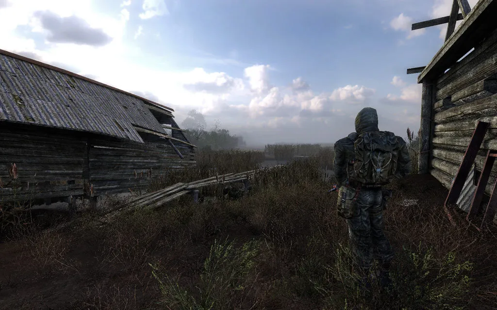 A lone stalker near wooden houses in the swamps in S.T.A.L.K.E.R. Clear Sky