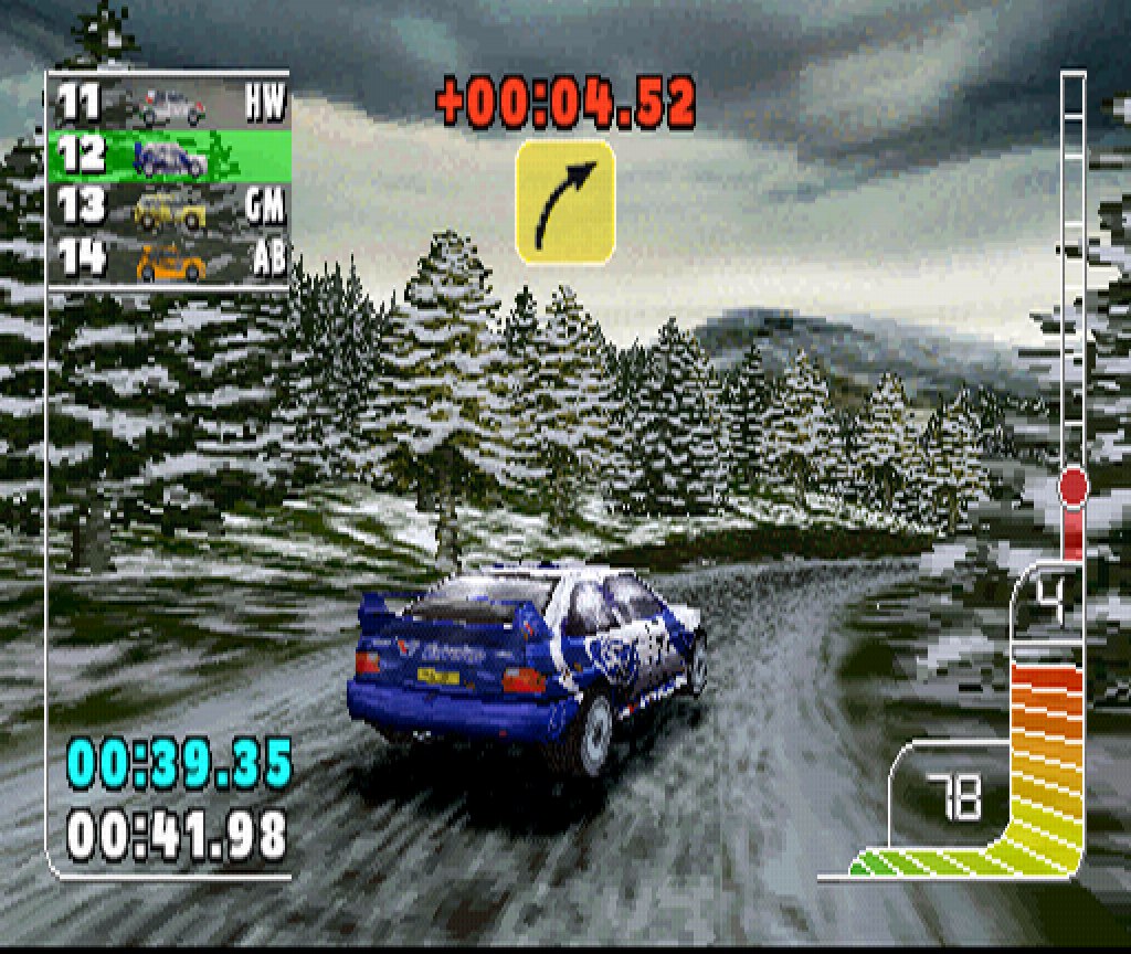 A Ford Escort WRC takes a bend on a Rally GB stage between snowy spruces, the co-driver's arrow at the top