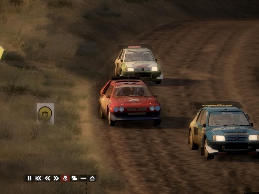 Three rally cars run nose to tail on a dusty track in replay mode